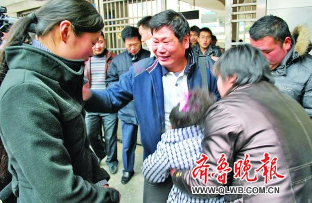 25日下午，在兖州火车站出站口，李双林（中）见到失散九年的女儿李薇（左）激动得泪流满面。