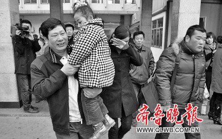 李双林抱着外孙女，和女儿一起回家。