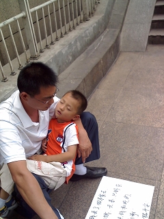 6月15日北京西客站被人抱着乞讨的孩子