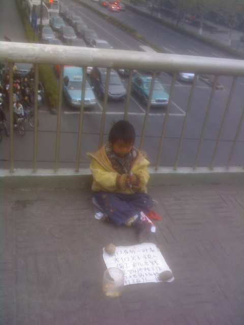 杭州延安路新华书店天桥上的2-3岁乞讨的小男孩